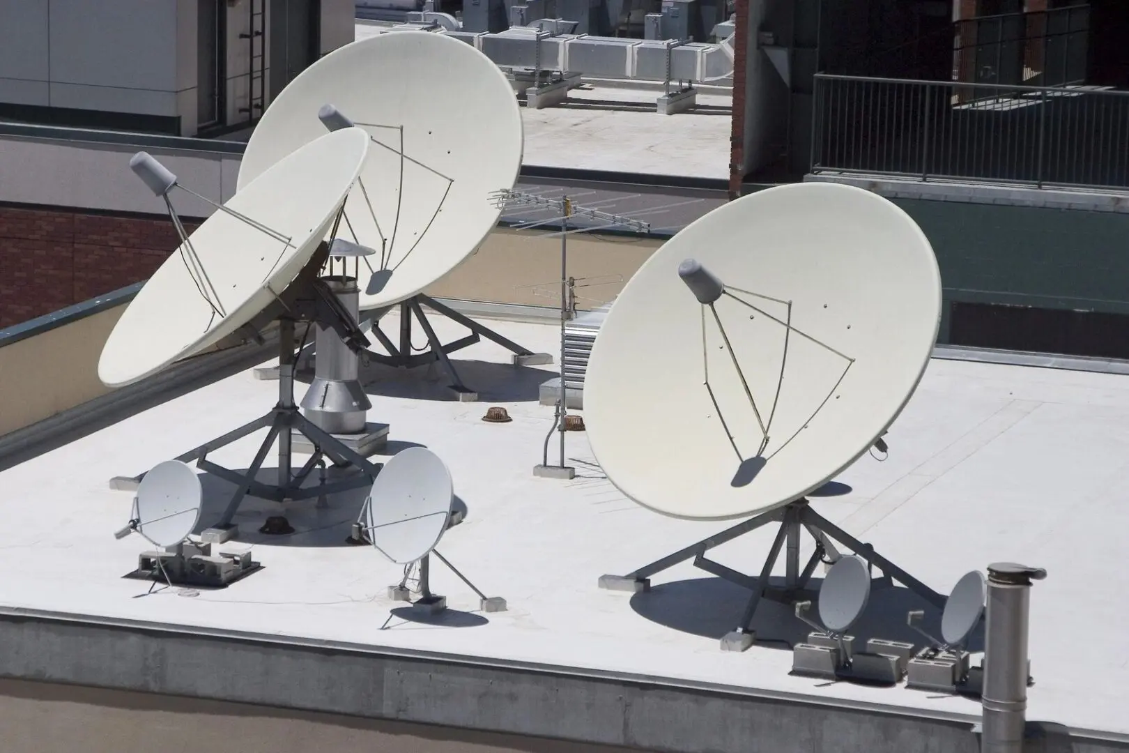 A group of satellite dishes sitting on top of a roof.