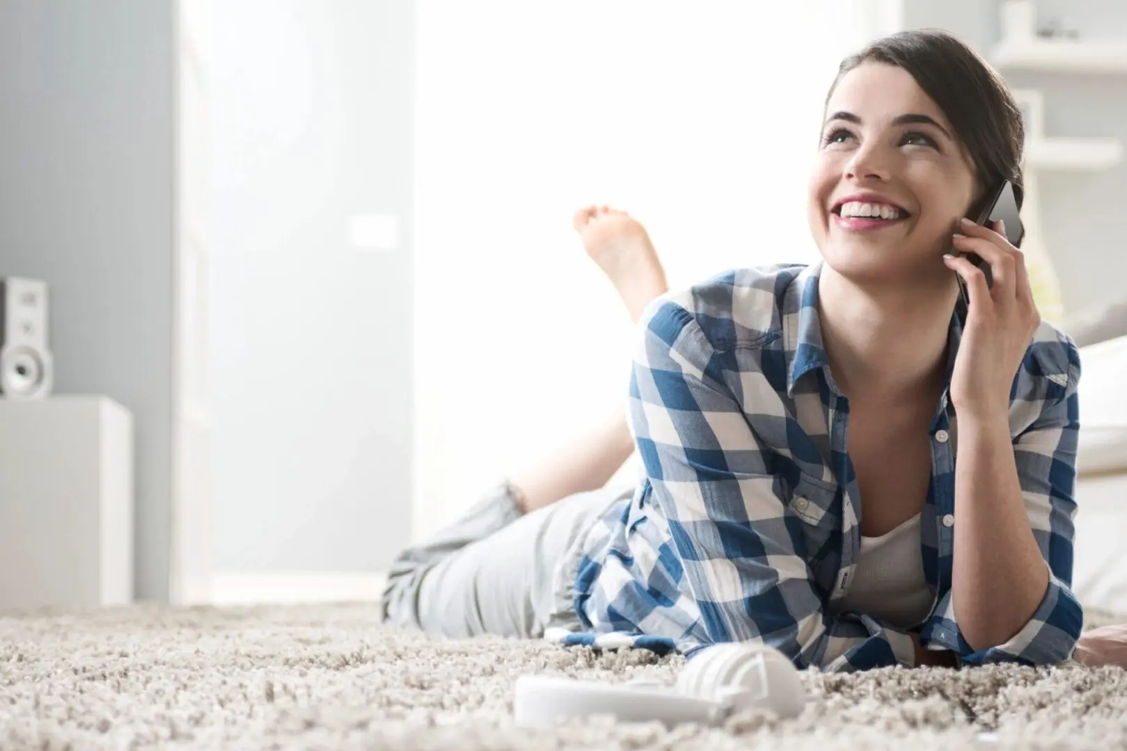 A woman laying on the ground smiling at the camera.